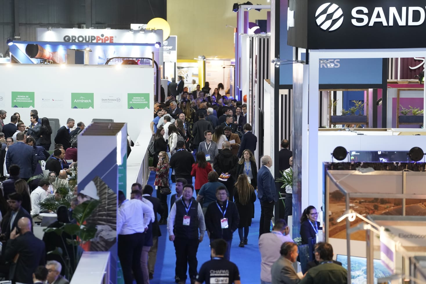 Personas recorriendo los pasillos de la exposición Arminera 2025, rodeadas de stands y empresas del sector minero.